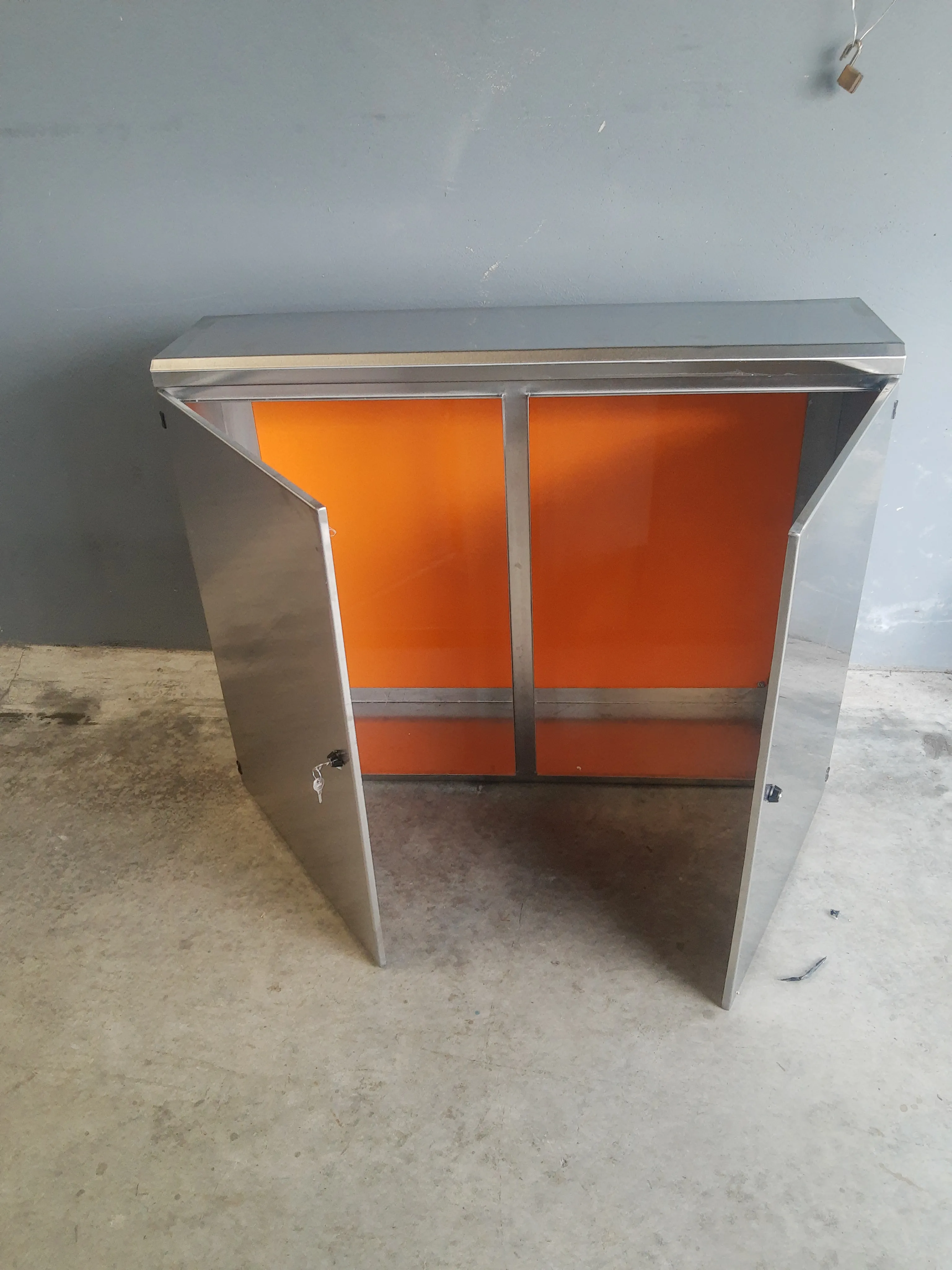 Painel elétrico em aço inox fixado em parede, porta aberta