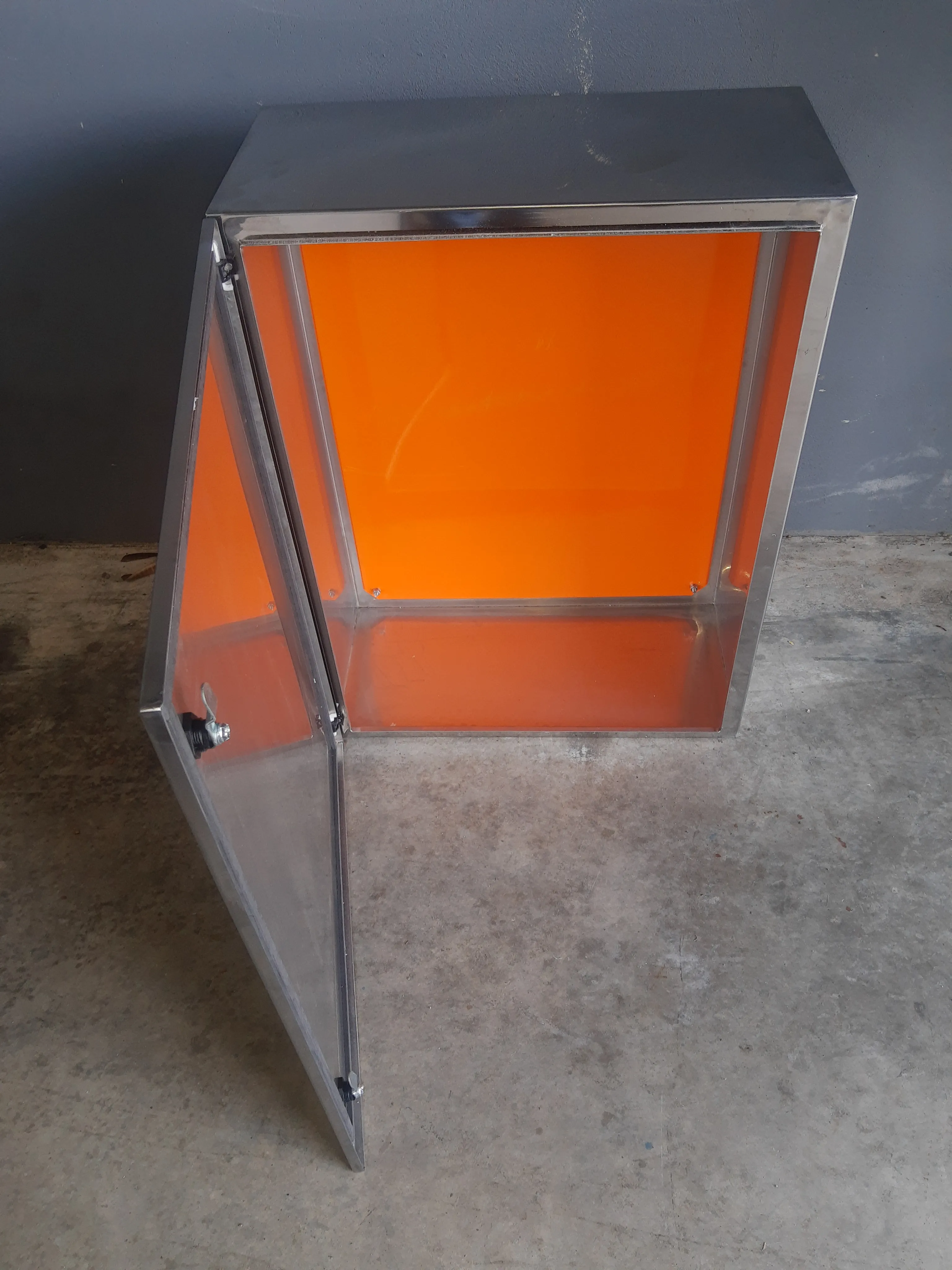 Painel elétrico em aço inox fixado em parede, vista em detalhe